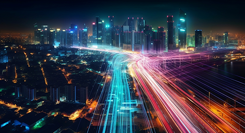A futuristic cityscape at night with skyscrapers and colorful light trails from fast-moving vehicles, symbolizing advanced technology and rapid movement.
