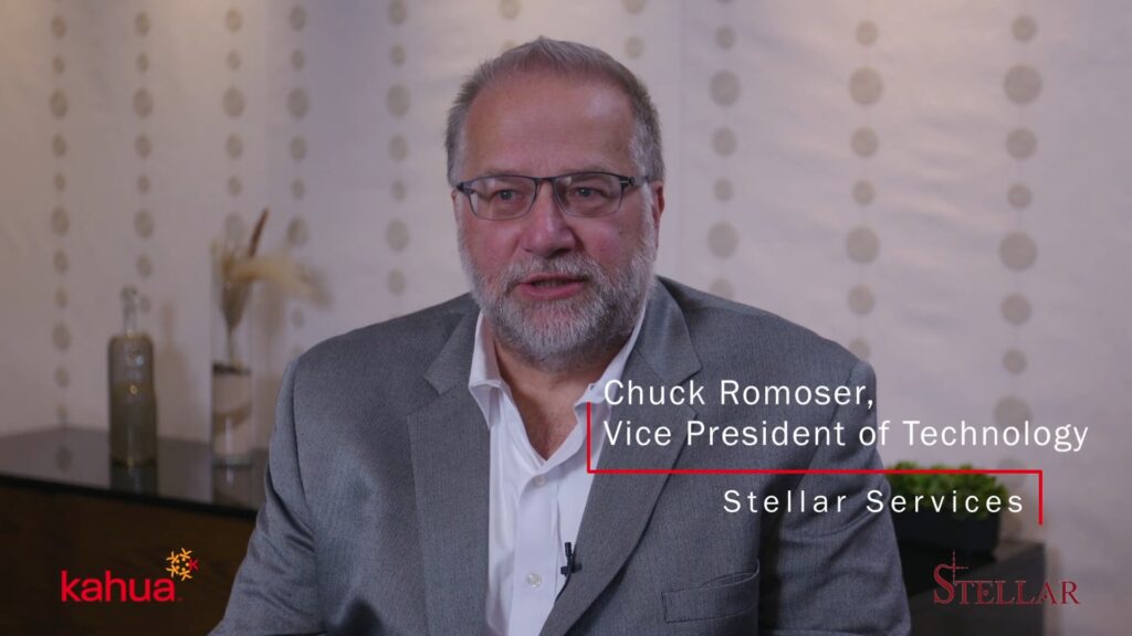 A man with glasses and a gray beard wearing a gray suit sits indoors. Text on the image reads: “Chuck Romoser, Vice President of Technology, Stellar Services.” Kahua and Stellar logos are visible.