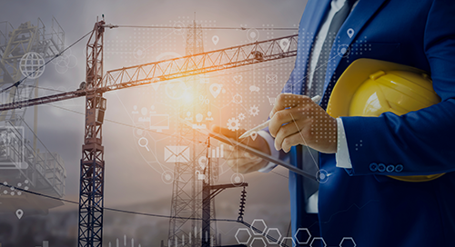 A person in a blue suit holds a yellow hard hat and uses a tablet, with construction cranes and digital graphics in the background, symbolizing technology in construction.