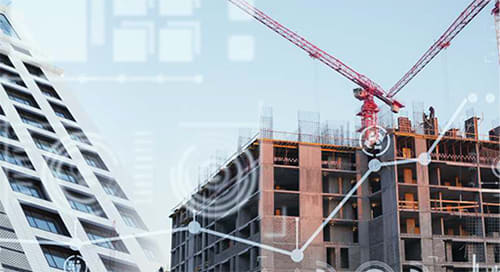 Two buildings under construction with cranes, one modern and triangular, overlaid with digital graphics representing data and technology, against a clear sky.